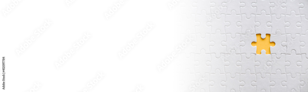 Top view of missing jigsaw puzzle on yellow background and white banner background with copy space. Top view of missing jigsaw puzzle on yellow background and white banner background with copy space.