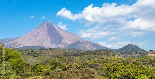 landscape with plants and the Colima volcano in the background, blue sky