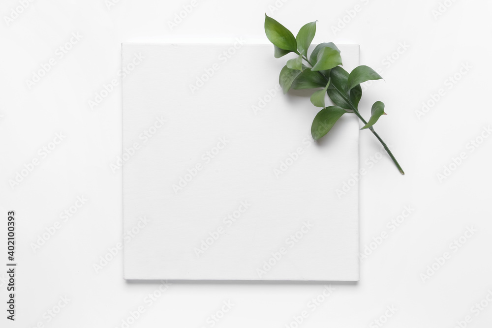 Blank paper sheet and green leaves on white background Blank paper sheet and green leaves on white background