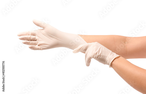 Woman putting on protective gloves on white background © Pixel-Shot