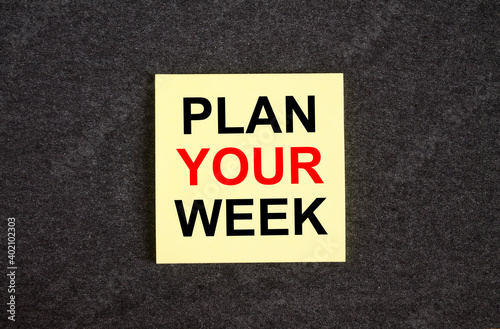 Yellow sticker on the dark gray texture background with text Plan Your Week