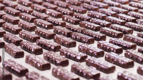 Lots of glazed sweets are moving along the conveyor photo