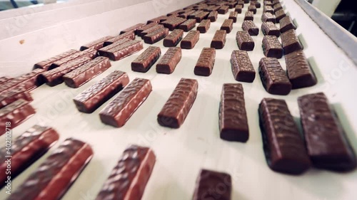 Conveyor belt with plenty of glazed sweets moving through it photo