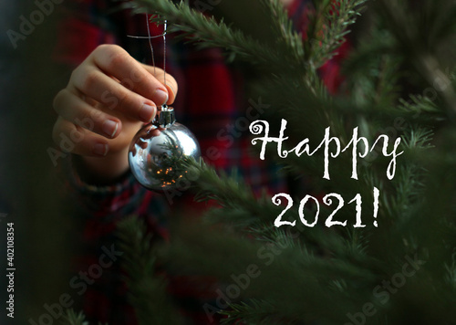 New Year card with child's hand holding a shiny ball and text 