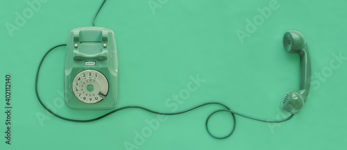 A green vintage dial telephone with green background.