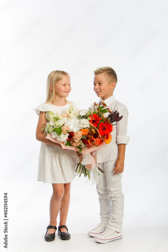 Studio portrait boy gives girl festive bouquet, congratulatory concept, white background, copy space