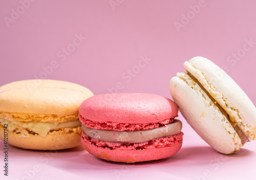 Fototapeta Naklejka Na Ścianę i Meble -  Colorful french cookies macarons set on pink background. Tasty fruit, almond sweet cookies, cake macaron