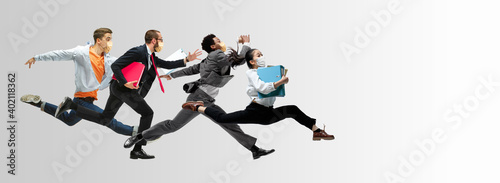 Fototapeta Naklejka Na Ścianę i Meble -  Happy office workers in face masks jumping and dancing in casual clothes or suit isolated on studio background. Business, start-up, prevention of COVID, motion and action concept. Creative collage.