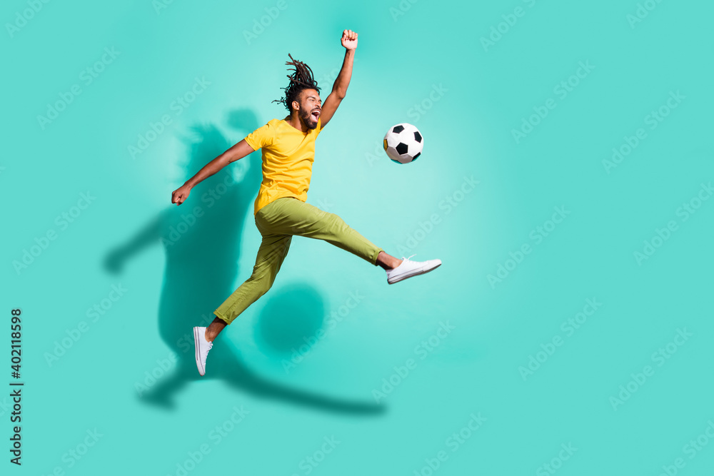 Full size profile side photo of young happy positive excited african man play football in air isolated on turquoise color background