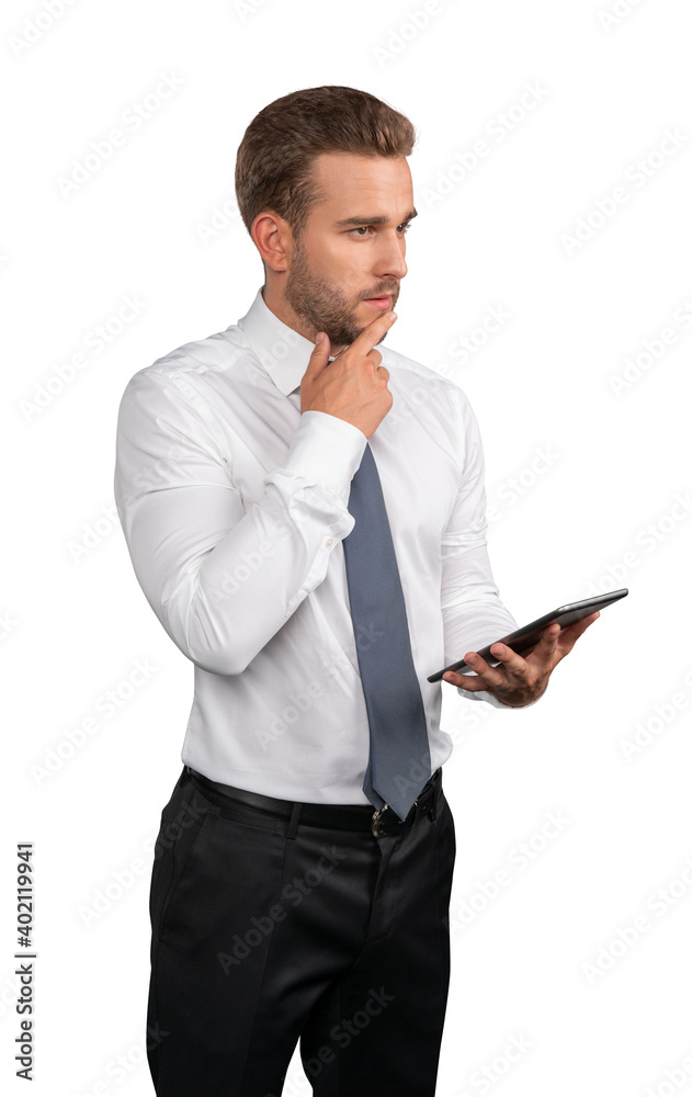 Businessman in shirt and tie standing thinking with tablet in hands, isolated over white background. Caucasian manager pensive, looking at the camera Businessman in shirt and tie standing thinking with tablet in hands, isolated over white background. Caucasian manager pensive, looking at the camera