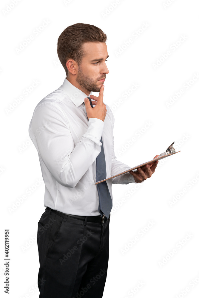 Businessman in white shirt and grey tie standing with clipboard in hand thinking, isolated over white background. Caucasian manager pensive look with clipboard Businessman in white shirt and grey tie standing with clipboard in hand thinking, isolated over white background. Caucasian manager pensive look with clipboard