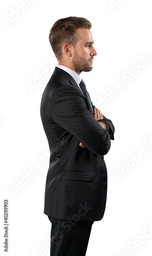 Businessman in black suit standing on isolated over white background. Young businessman arms crossed, profile shot, confident look