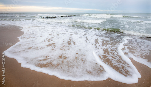Fototapeta Naklejka Na Ścianę i Meble -  Sea wave pouring out on the seashore. Foaming waters of the Baltic Sea.