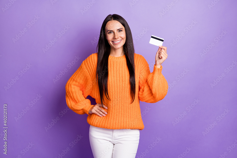 Portrait of pretty person hold banking card put hand on waist wear pullover isolated on purple color background Portrait of pretty person hold banking card put hand on waist wear pullover isolated on purple color background
