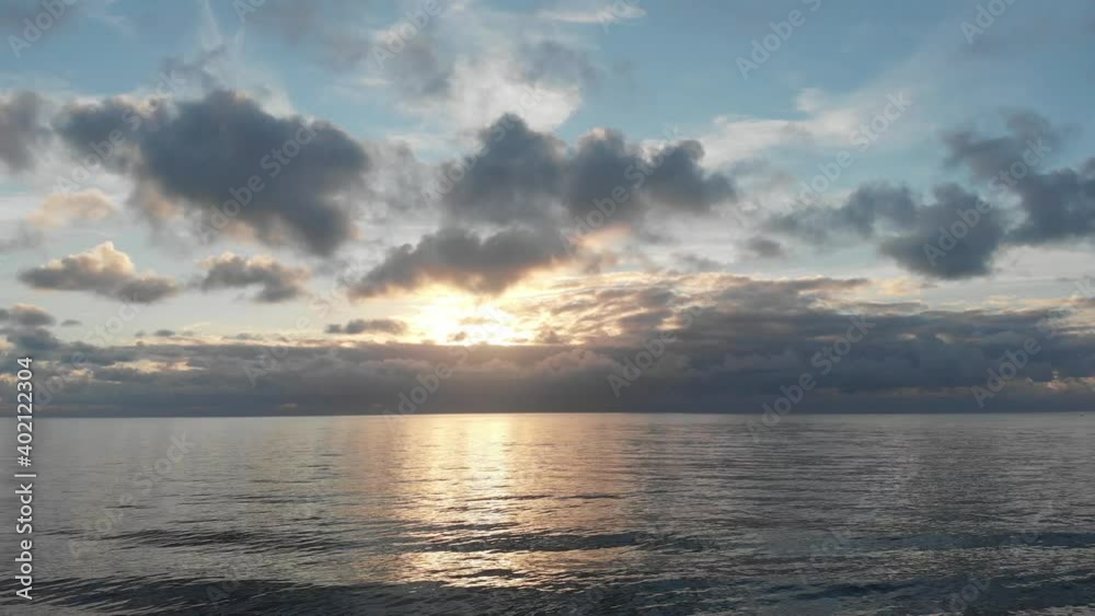 Fantastic sky at sunset over ocean with suggestive sun rays hitting wavy silky water Fantastic sky at sunset over ocean with suggestive sun rays hitting wavy silky water