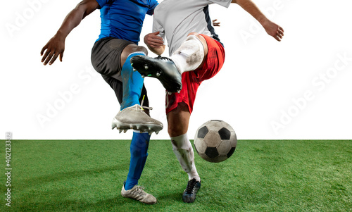 Close up legs of professional soccer, football players fighting for ball on field isolated on white background. Concept of action, motion, high tensioned emotion during game. Cropped image. © master1305