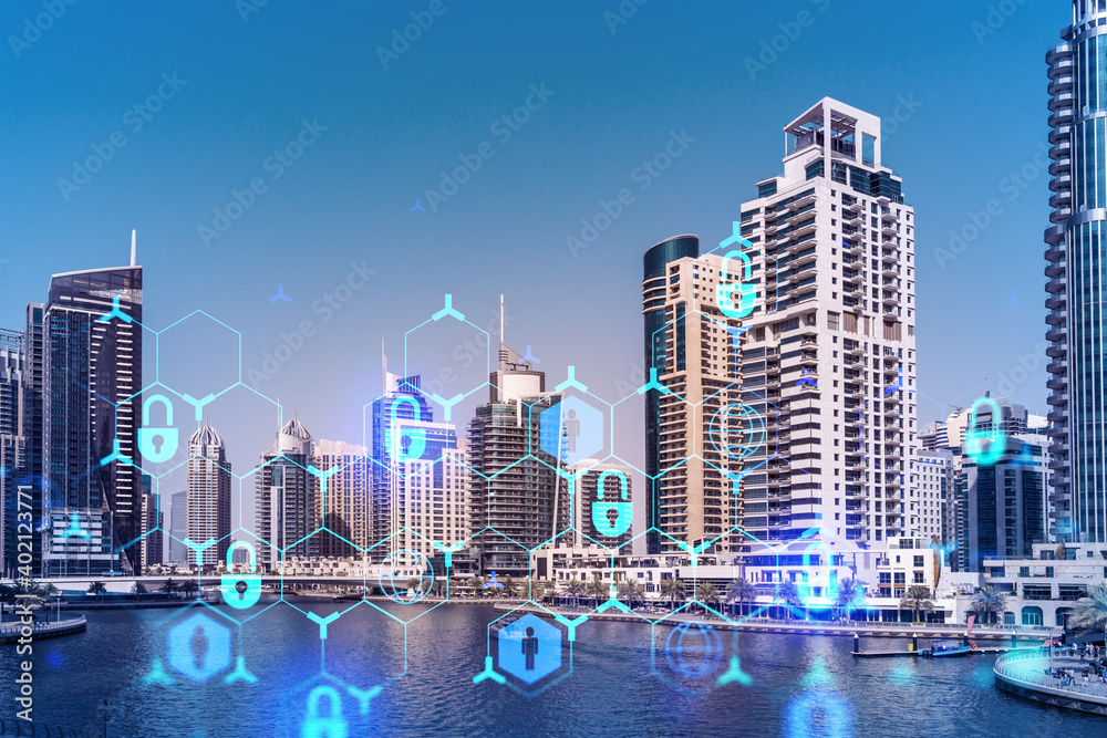 Fototapeta premium Skyscrapers of Dubai business downtown. International hub of trading and financial services. Lock icon hologram, concept of datum security. Double exposure. Dubai Canal waterfront.