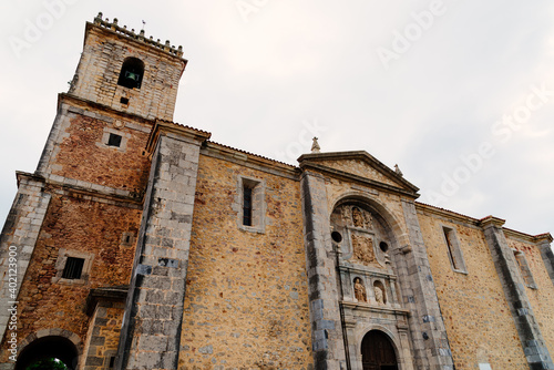 The church of the small town of Isla in Cantabria, Spain. Exterior view against cloudy sky