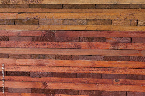 Stained wood background with grain in assorted colours of red and brown