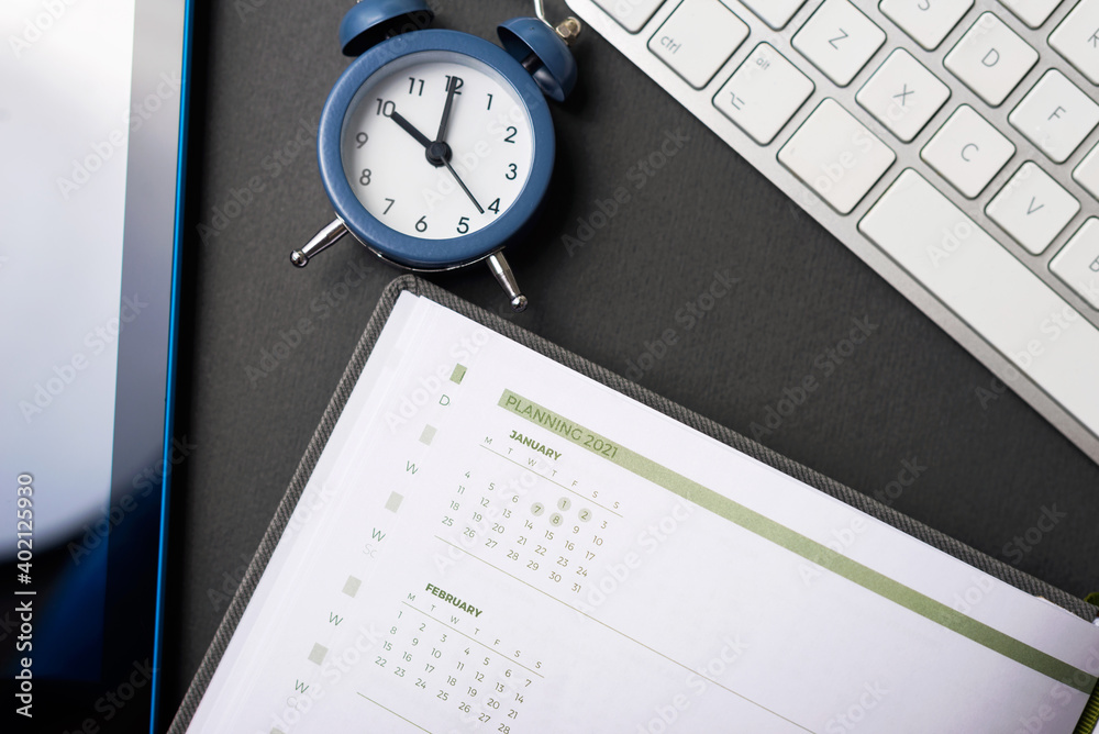 Time to planning 2021 year, photo of work desk with clock agenda and keyboard. Time to planning 2021 year, photo of work desk with clock agenda and keyboard.