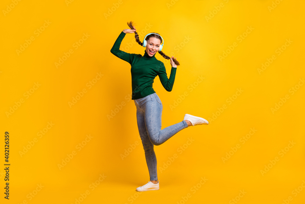 Full length body size photo female student enjoying music wearing headphones smiling isolated on vibrant yellow color background