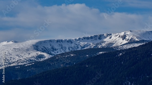 Beautiful winter panoramic natural mountain landscape. Attractive snowy peaks of Rila Mountains, Bulgaria. White clouds in dynamic blue sky, perfect conditions for tourism recreation and winter sports © Miglena Pencheva