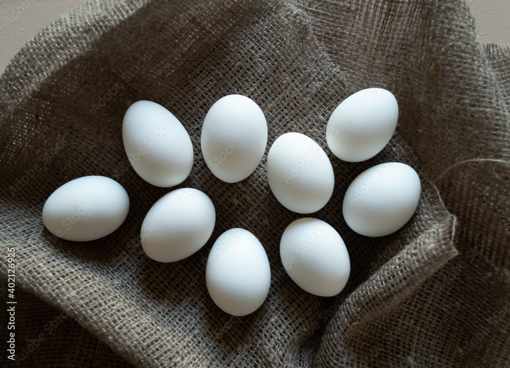 White chicken eggs on a coarse linen napkin White chicken eggs on a coarse linen napkin