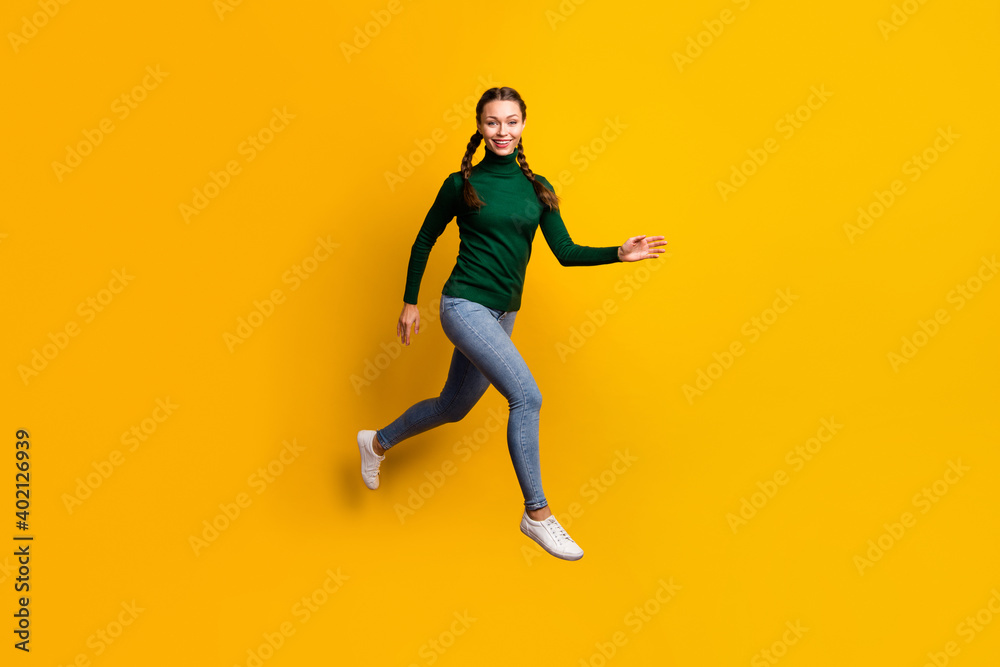 Full length body size photo smiling woman jumping high in casual clothes isolated on bright yellow color background