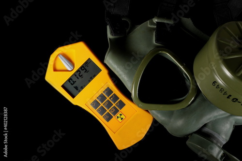 Military gas mask with Geiger counter, radiation detection device isolated on black background with clipping path, top view