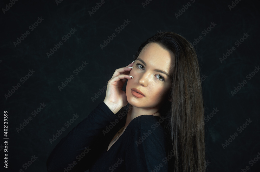 Portrait of a young beautiful woman in the studio on a dark background Portrait of a young beautiful woman in the studio on a dark background