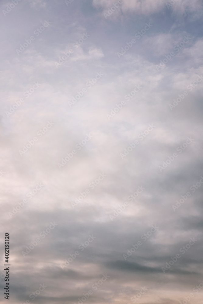 Beautiful blue dramatic sky with clouds at sunrise. Background. Space for text. Vertical.