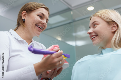 Low angle shot of a cheerful woman talking to her dentist after dental checkup