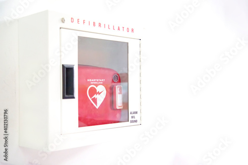 Automated External Defibrillator (AED) in white box on the wall Is an emergency pacemaker device for people with cardiac arrest. Heart defibrillator on white background..