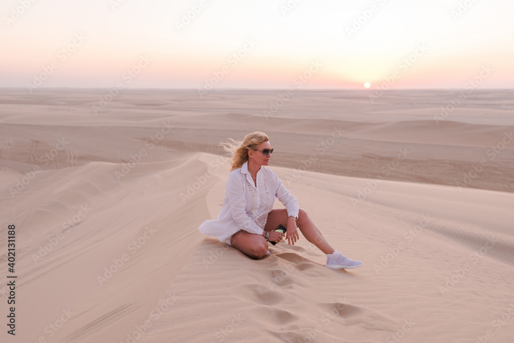Woman on a hill in the desert at sunset, Qatar