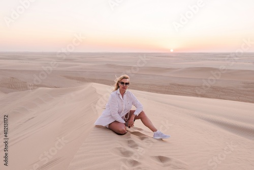 Woman on a hill in the desert at sunset, Qatar © Visionsi