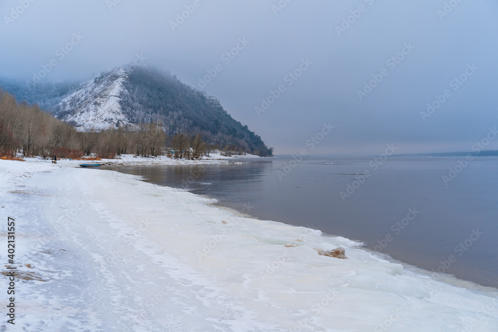 Frozen Volga River coast, winter landscape with snow and mountains