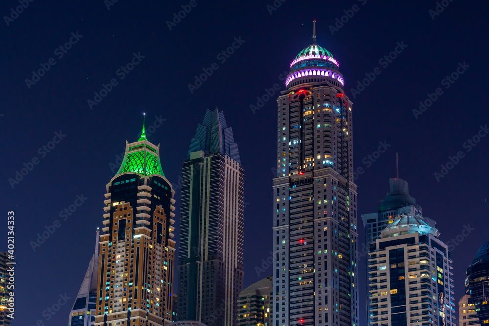Night view to iconic skyscrapers panorama of Dubai Marina. Amazing illumination of the buildings. Close-up shot at blue hour.