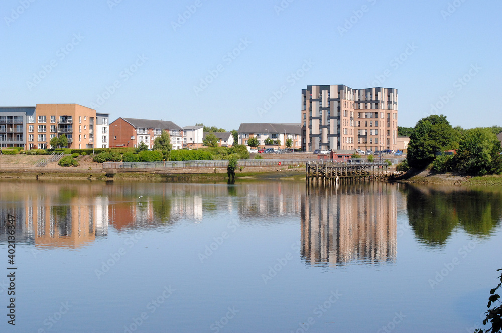 Reflections of Blue Sky & Buildings in Still Waters of River 