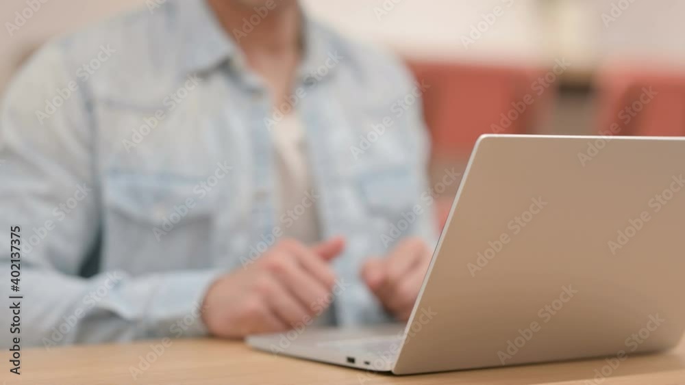 Man showing Thumbs Down while using Laptop, Close up Man showing Thumbs Down while using Laptop, Close up