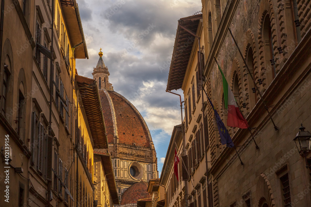 Florence Cathedral, formally named Cathedral of Saint Mary of the Flower, in the Piazza del Duomo, Florence, Tuscany, Italy seen on a cloudy day from an alley.  
