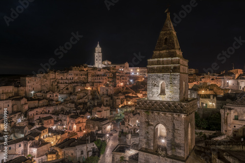 View of the Sassi of Matera at night. The tower in the foreground is the bell tower of the Church of San Pietro Barisano, the tower on the second floor is the bell tower of the Pontifical Basilica