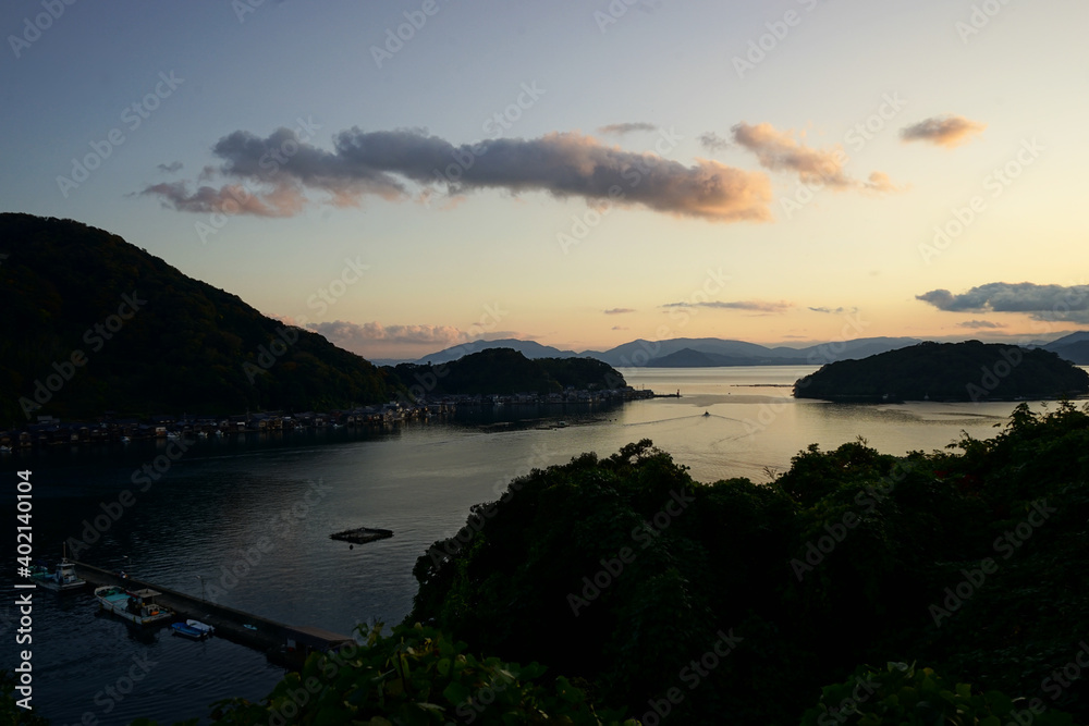 Fototapeta premium Aerial View of Ine bay and Funaya, boat houses, with beautiful sunset from Observation deck in Autumn, Ine city, Kyoto, Japan - 京都 舟屋群展望所から見た伊根湾の夕日