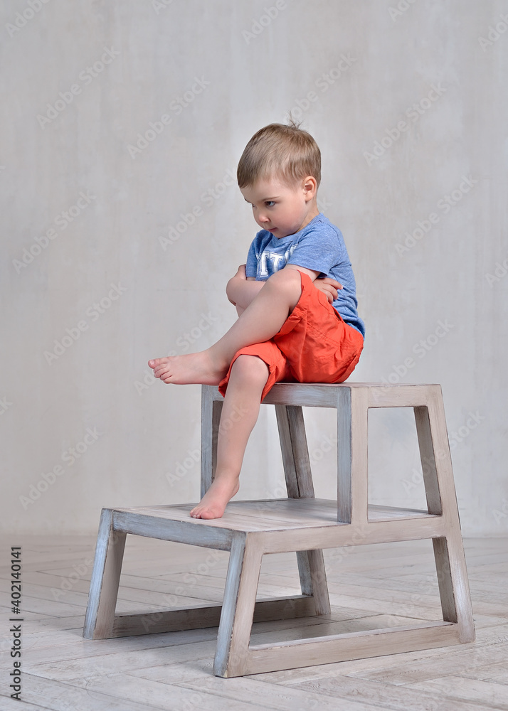 the offended boy is sitting on a chair the offended boy is sitting on a chair