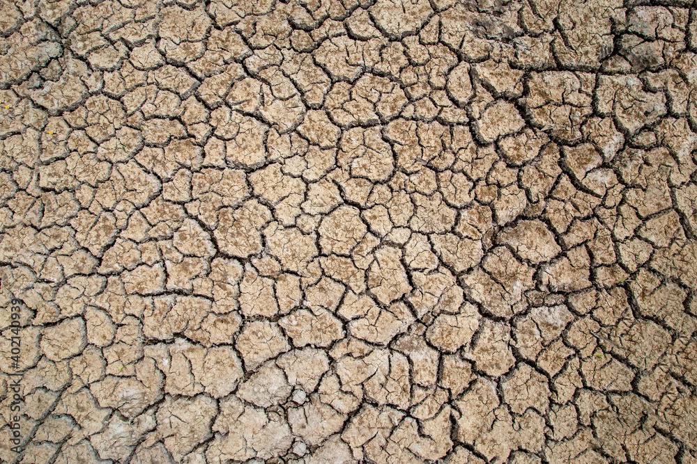 Cracked soil in the summer with the sun. Cracks of the dried soil in arid season at rural Thailand. Cracked soil in the summer with the sun. Cracks of the dried soil in arid season at rural Thailand.