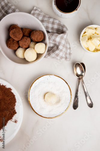Fototapeta Naklejka Na Ścianę i Meble -  Homemade Indian round vegetarian sweets. Coconut and cocoa balls in a white bowl with coconut shavings