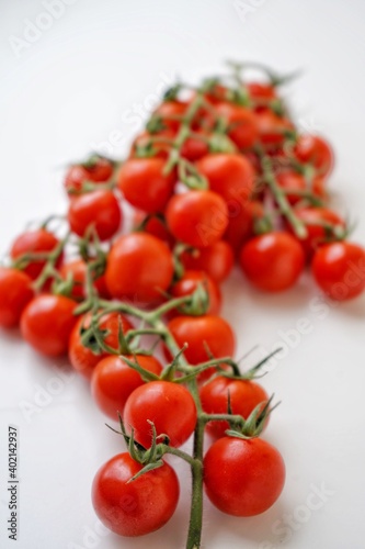 Bunch of fresh, red tomatoes with green stems isolated on white background. photo