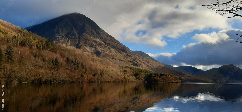 View over Crummock water from the shoreline on a sunny winter day with reflections on the still water