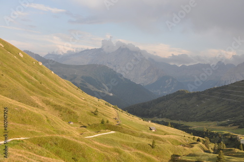 Szlak schodzi do doliny pośród zielonych wzgórz, Dolomity, Włochy