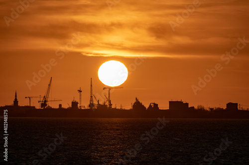 Breathtaking sunset on the north sea coast near Emden with aindustrial silhouette in the background photo