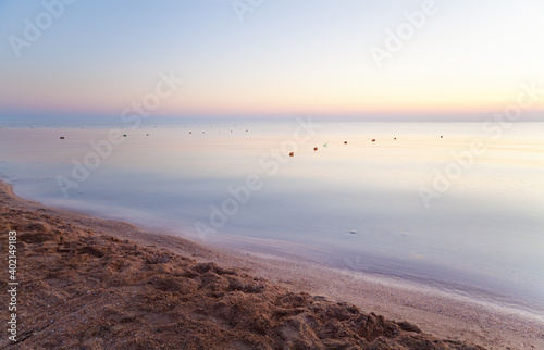Amazing sea sunrise with calm morning waves. Relaxing picture of perfect summer vacation.